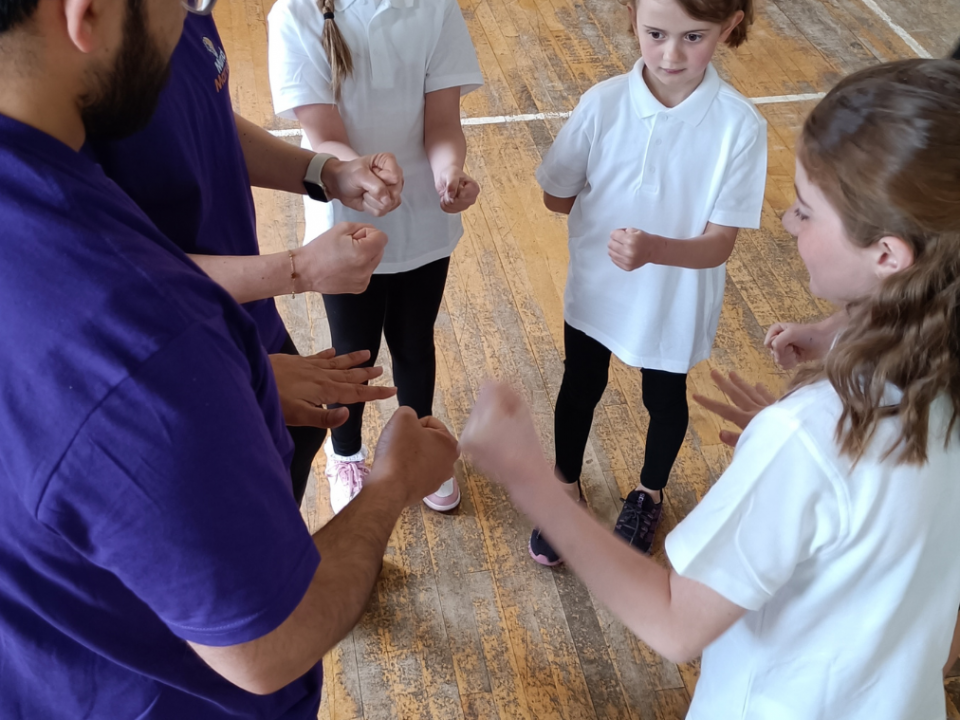session leader with children in a circle playing game