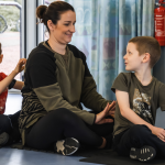 Mindful massage with parent at Mind Marvels session. the boy is looking and smiling at the woman.